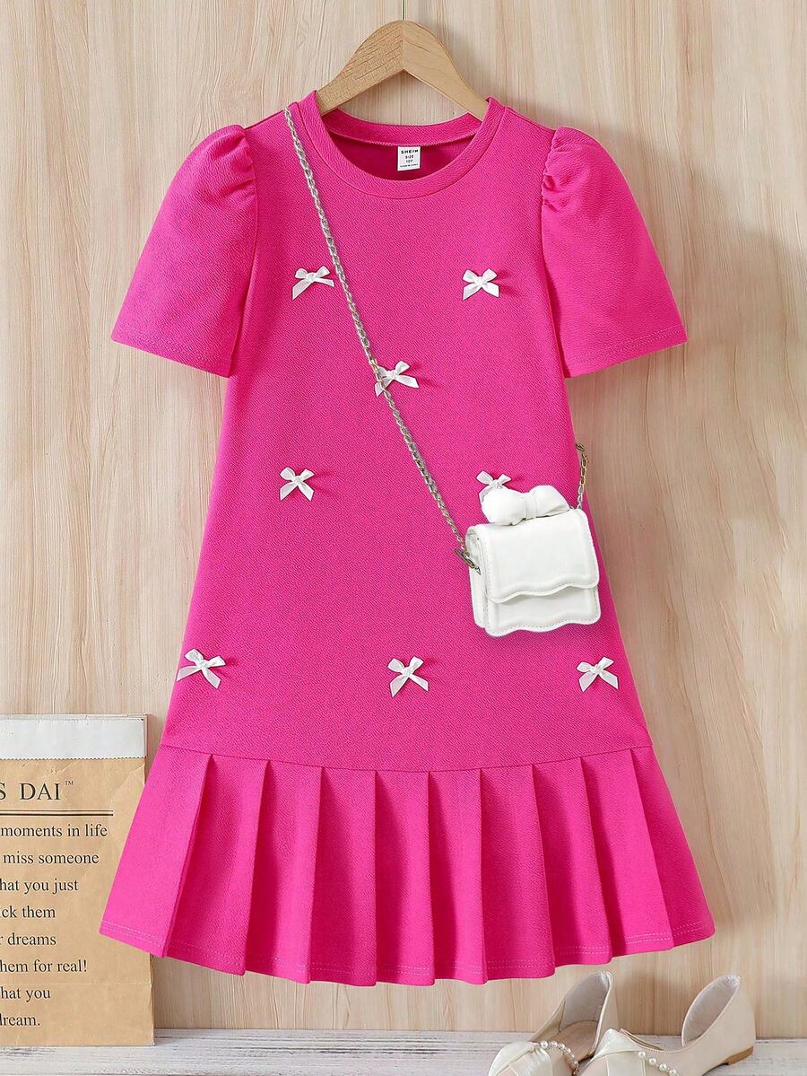 Tween girls apricot short-sleeve pleated smock dress with 3D bow decor and round neckline.