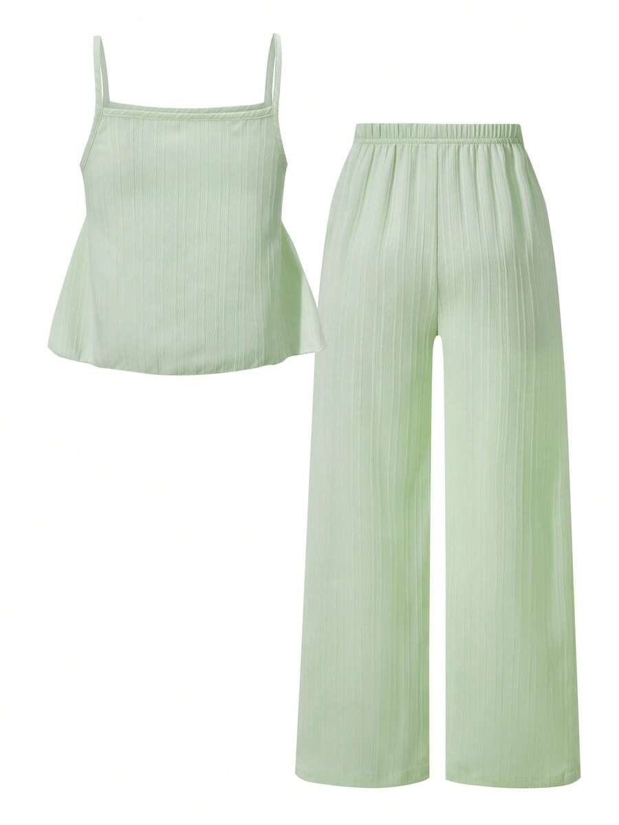 Tween girl wearing an apricot 2-piece outfit set featuring a shirred spaghetti strap short cami top and matching wide-leg long pants.