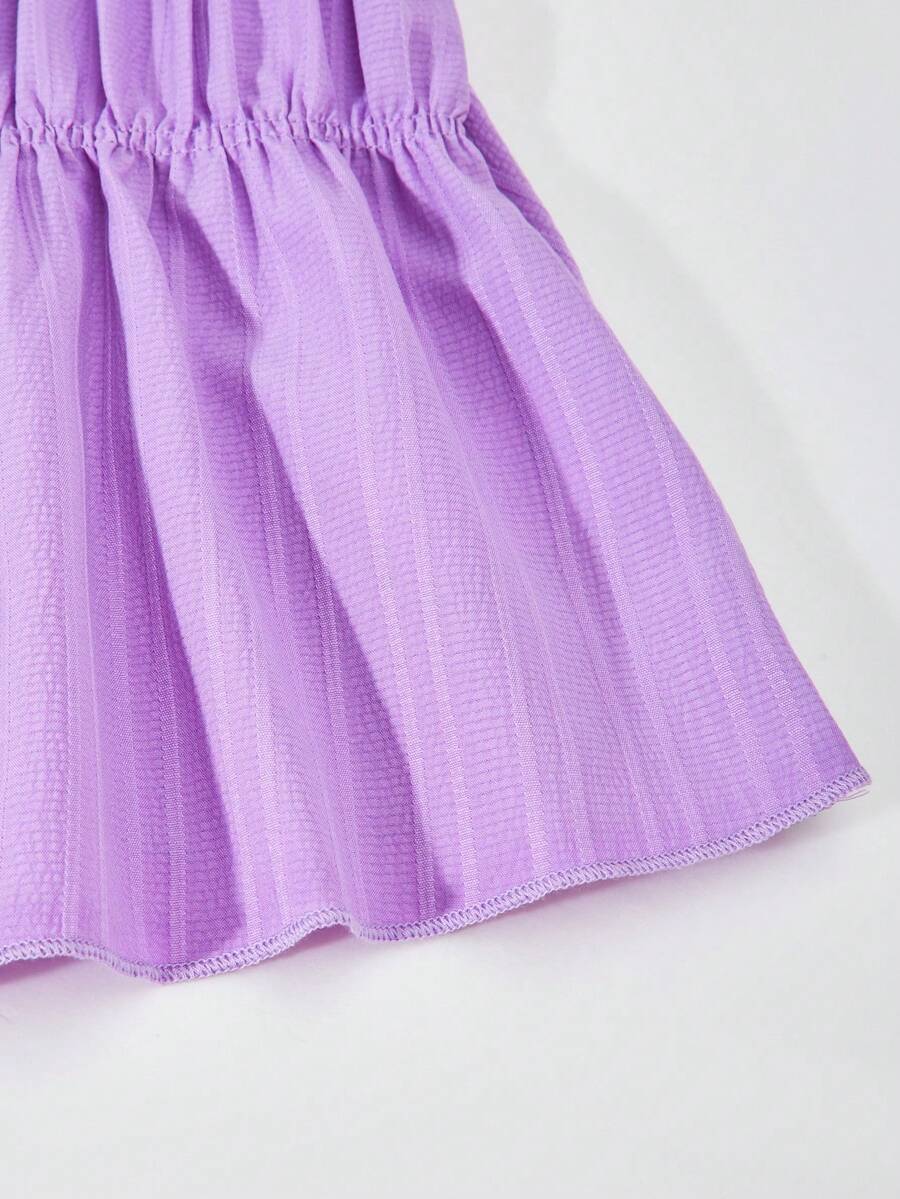 Tween girl wearing an apricot 2-piece outfit set featuring a shirred spaghetti strap short cami top and matching wide-leg long pants.