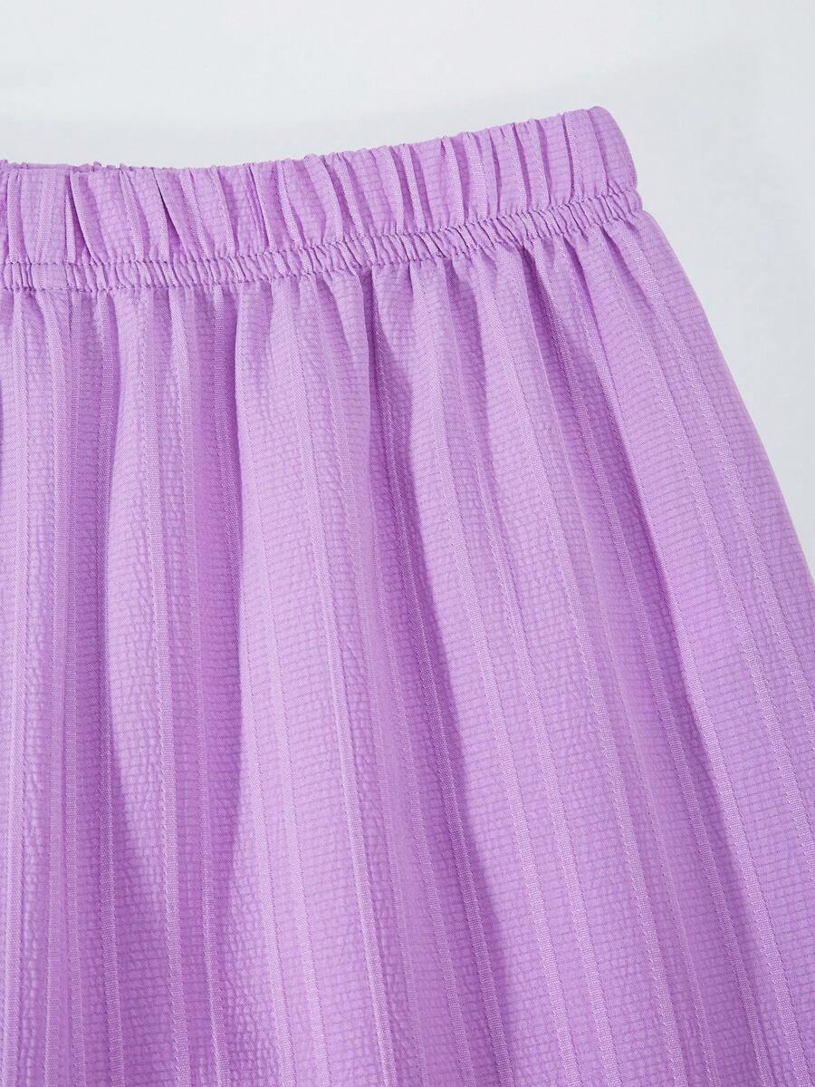 Tween girl wearing an apricot 2-piece outfit set featuring a shirred spaghetti strap short cami top and matching wide-leg long pants.