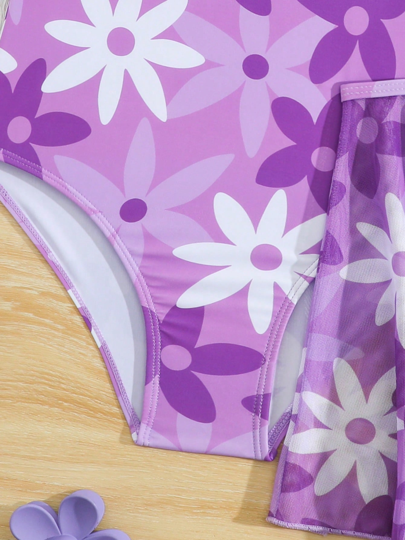 Blue tween girls one-piece swimsuit with tropical plant print, spaghetti straps, ruffle detail, and skirt-style mid-waist bottom for beach and pool wear.