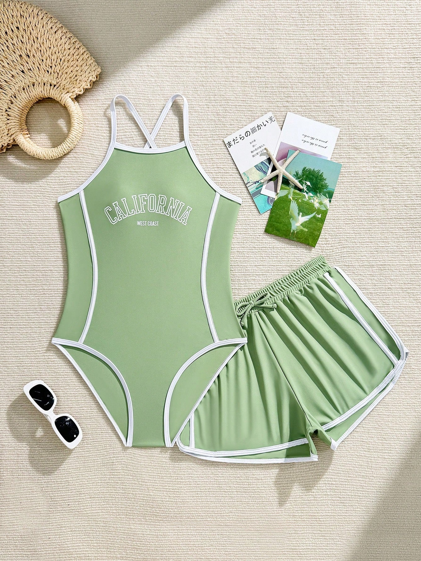 Girls' mauve purple one-piece swimsuit with swim shorts, spaghetti straps, contrast piping, letter pattern, and sleeveless vacation swimwear design.