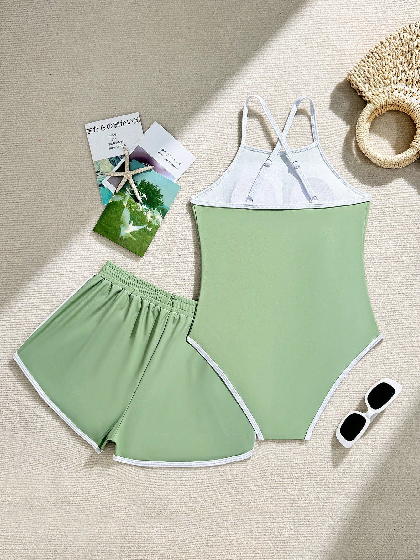 Girls' mauve purple one-piece swimsuit with swim shorts, spaghetti straps, contrast piping, letter pattern, and sleeveless vacation swimwear design.