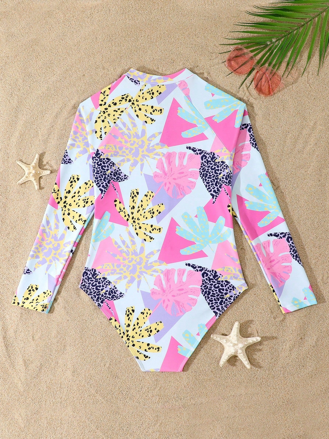 Girls one-piece swimsuit in blue with all-over leopard leaf print, ruffle detail, zipper front, high neck, and lined body for swimming and vacation.