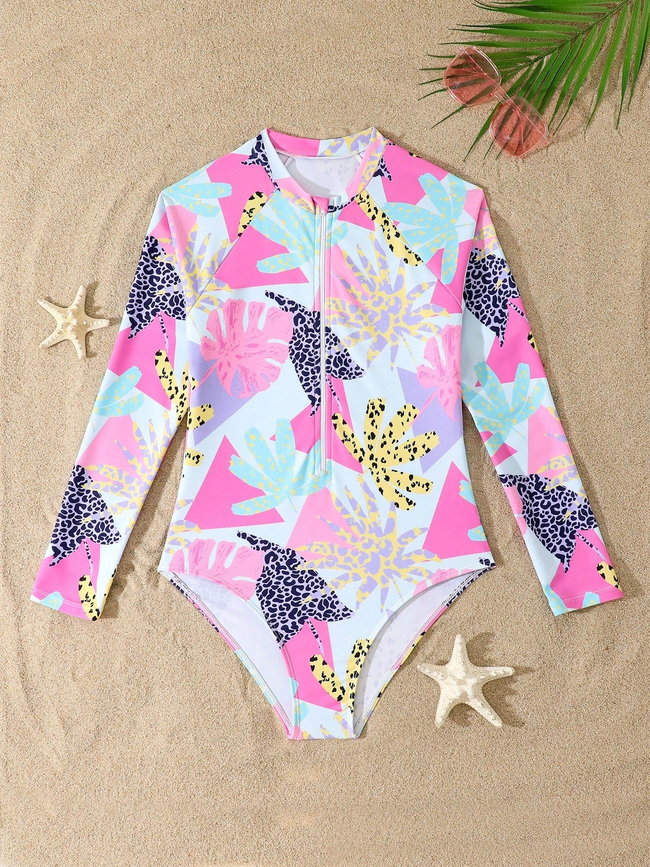 Girls one-piece swimsuit in blue with all-over leopard leaf print, ruffle detail, zipper front, high neck, and lined body for swimming and vacation.