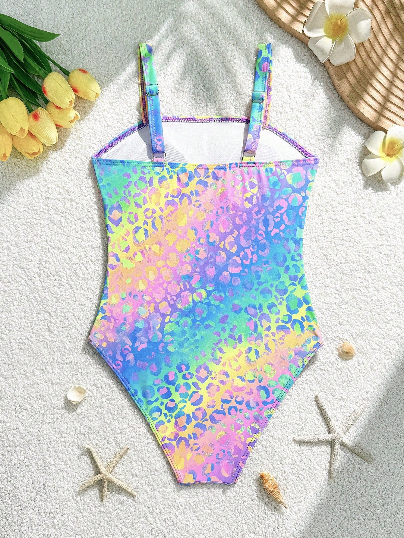 Tween girls one-piece swimsuit with a floral plant print, spaghetti straps, and a mid-waist fit in black.