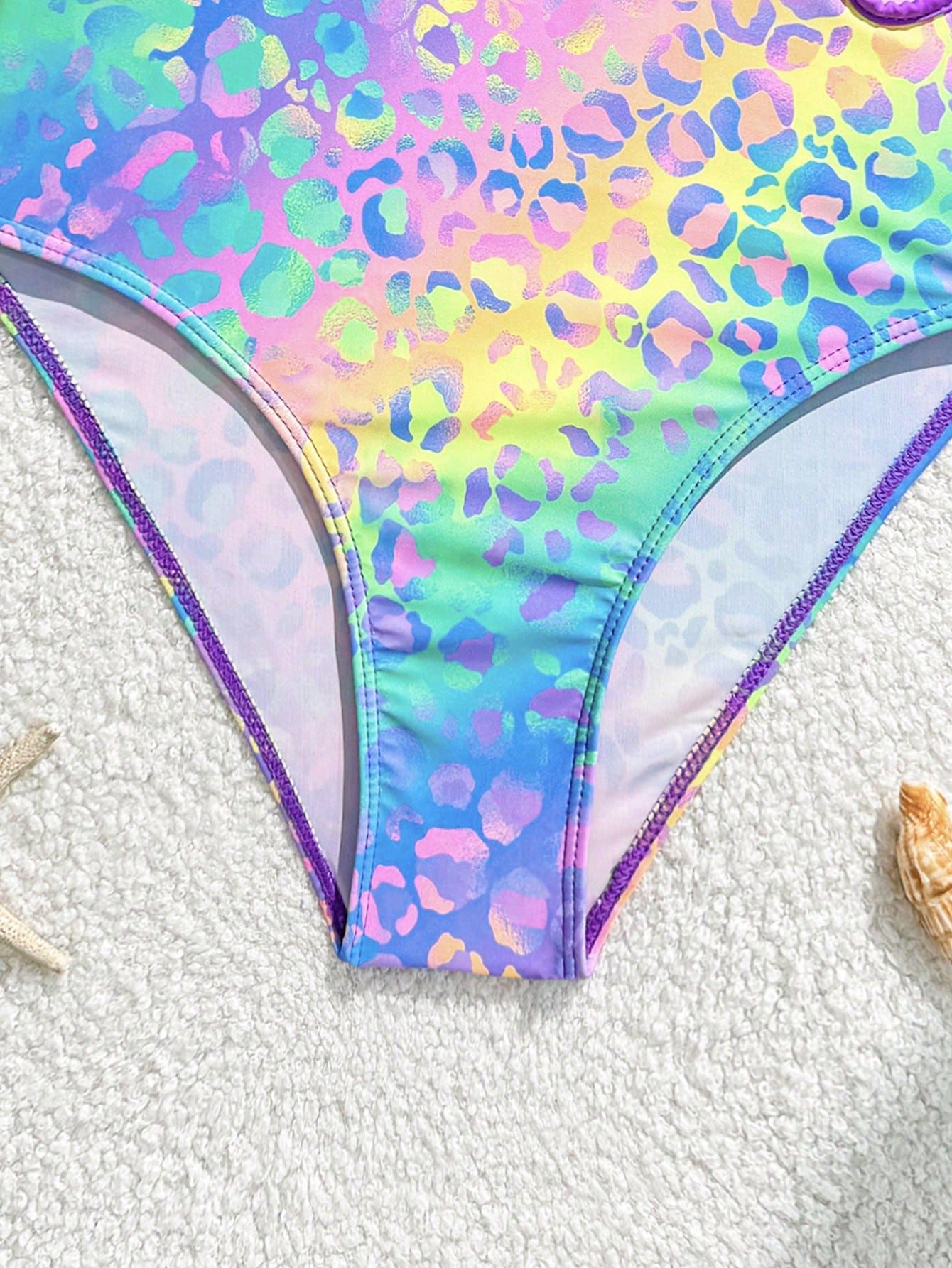 Tween girls one-piece swimsuit with a floral plant print, spaghetti straps, and a mid-waist fit in black.