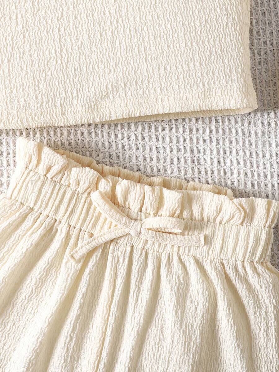 Tween girl 2-piece casual outfit set featuring a solid beige knit halter sleeveless top with belted detail and matching shorts.