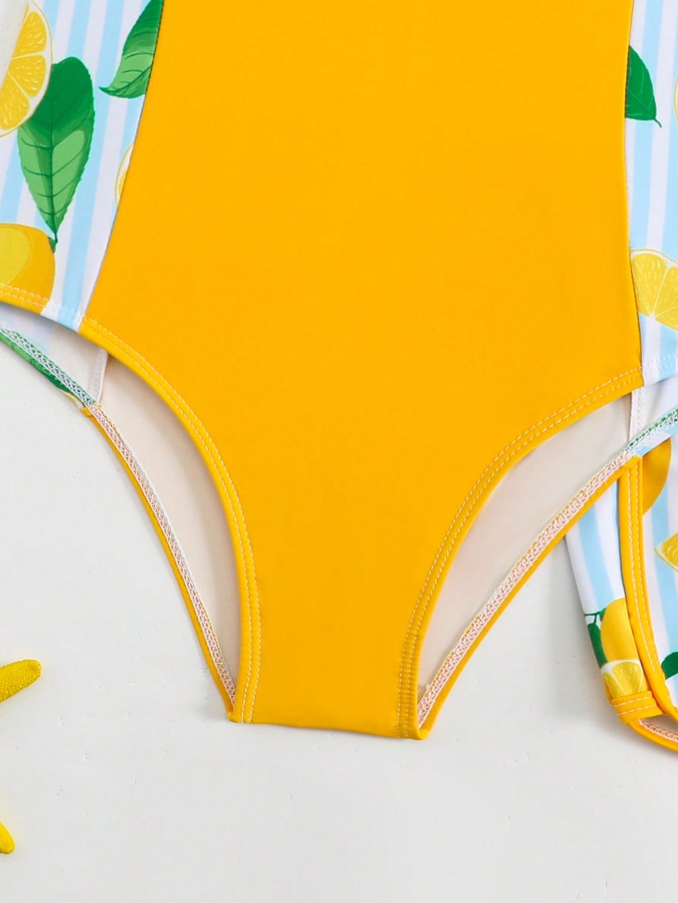 Tween girls 2-piece swimsuit set with a printed one-piece featuring ruffle trim, scoop neckline, cut-out detail, and matching shorts bottom.