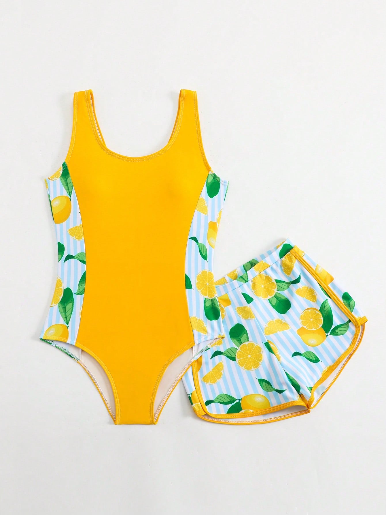 Tween girls 2-piece swimsuit set with a printed one-piece featuring ruffle trim, scoop neckline, cut-out detail, and matching shorts bottom.