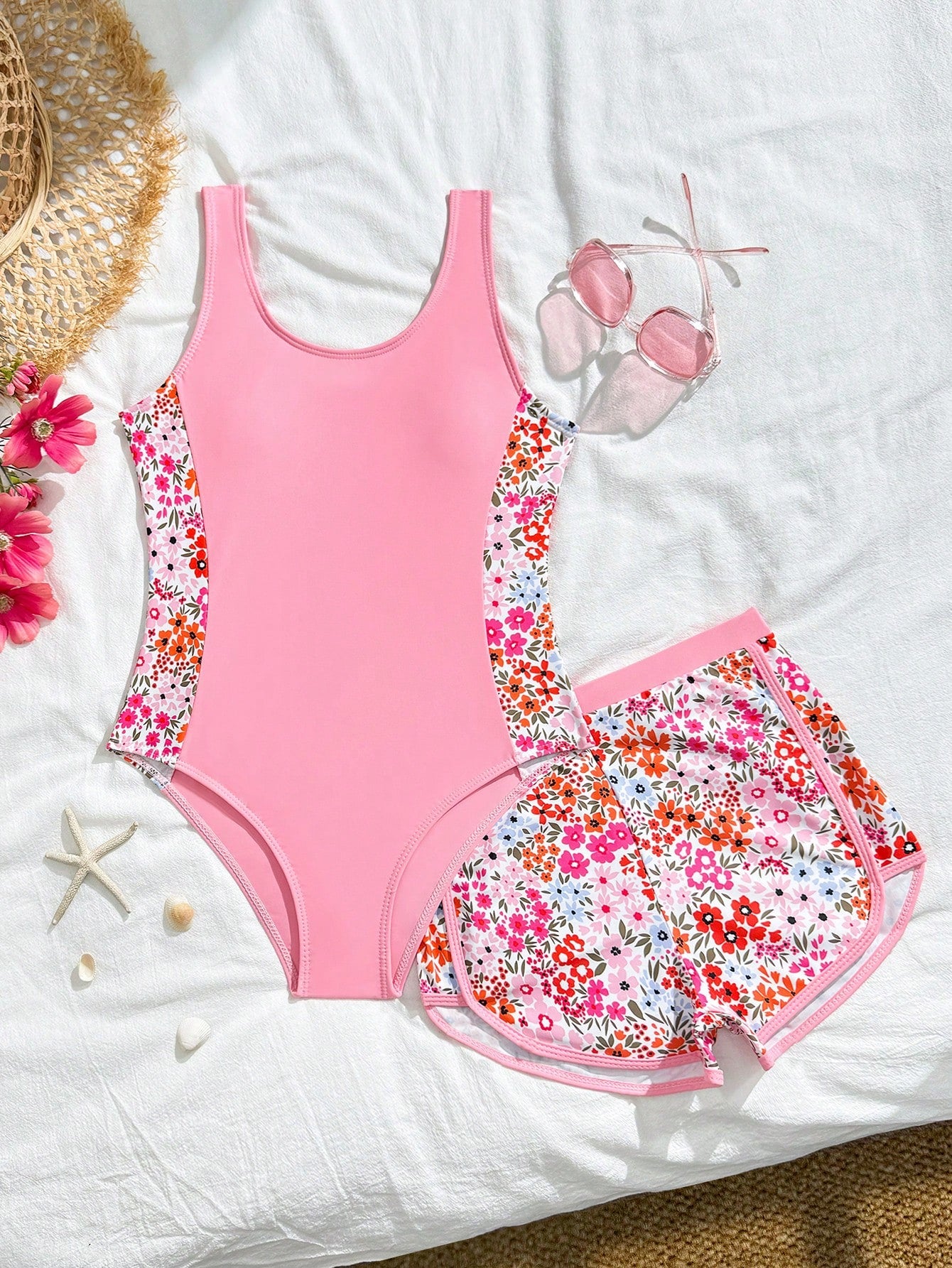 Tween girls 2-piece swimsuit set in black with full floral and plant print, featuring a sleeveless scoop-neck swim top and matching shorts-style bottoms.