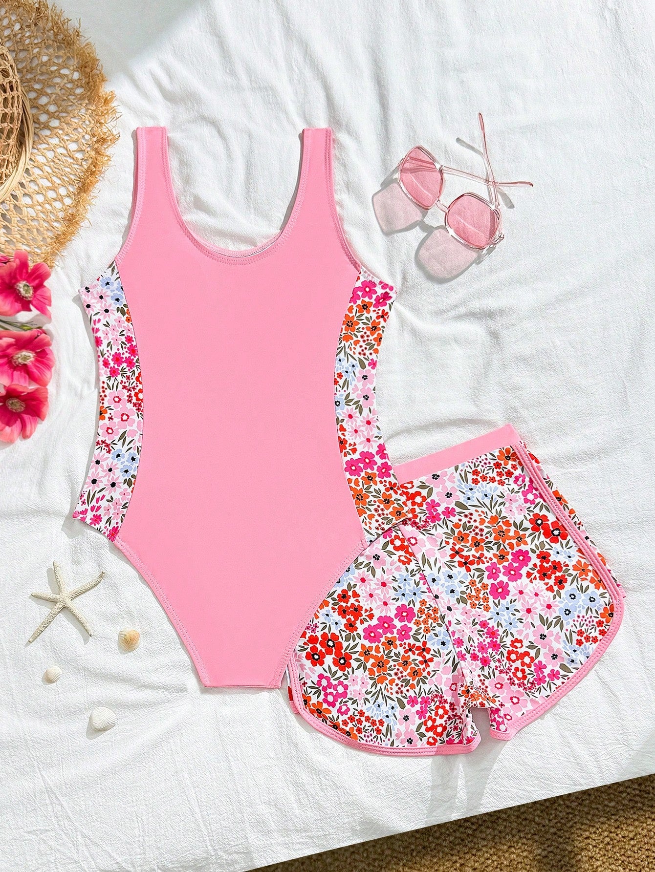 Tween girls 2-piece swimsuit set in black with full floral and plant print, featuring a sleeveless scoop-neck swim top and matching shorts-style bottoms.