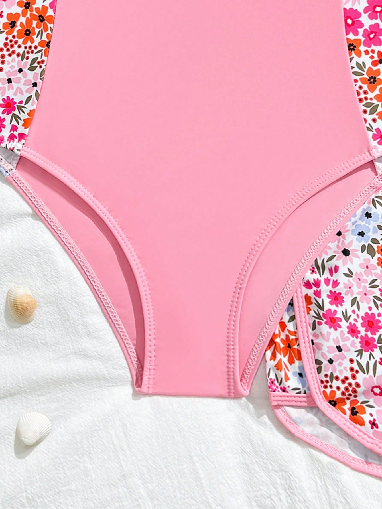 Tween girls 2-piece swimsuit set in black with full floral and plant print, featuring a sleeveless scoop-neck swim top and matching shorts-style bottoms.