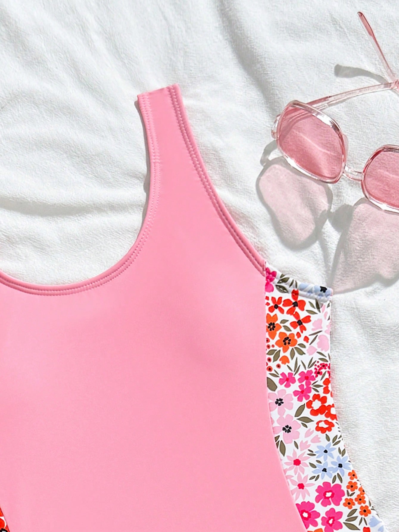 Tween girls 2-piece swimsuit set in black with full floral and plant print, featuring a sleeveless scoop-neck swim top and matching shorts-style bottoms.