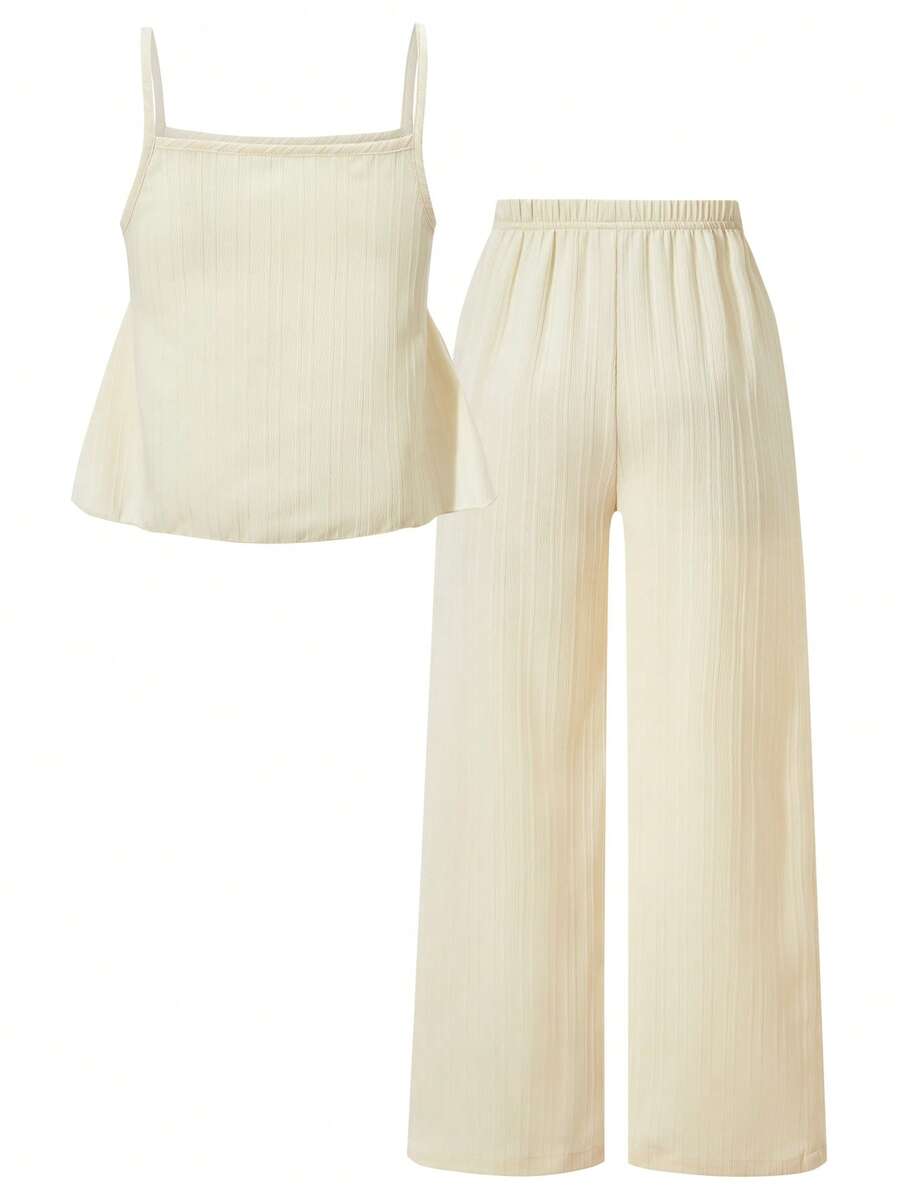 Tween girl wearing an apricot 2-piece outfit set featuring a shirred spaghetti strap short cami top and matching wide-leg long pants.