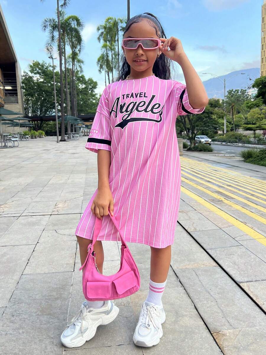 Tween girl wearing a pink streetwear oversized short sleeve t-shirt dress featuring a round neck, drop shoulders, and pleated split details.