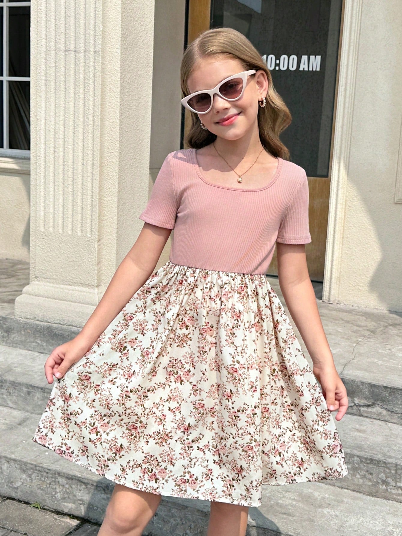 Tween girl wearing an apricot short sleeve A-line dress featuring a round neck, high waist with a belt, and flared hem.