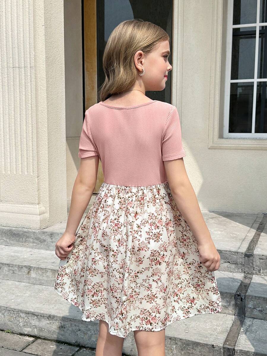 Tween girl wearing an apricot short sleeve A-line dress featuring a round neck, high waist with a belt, and flared hem.