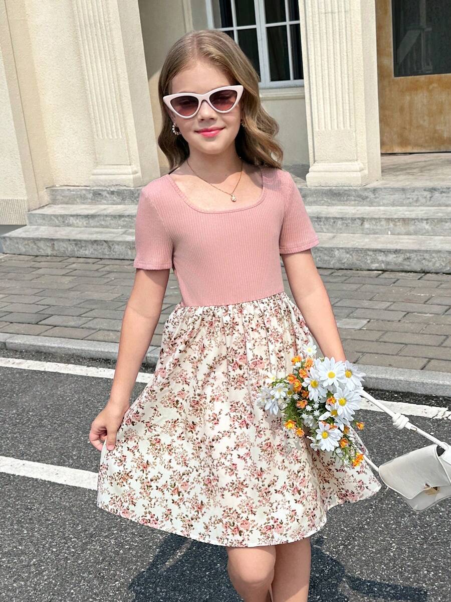 Tween girl wearing an apricot short sleeve A-line dress featuring a round neck, high waist with a belt, and flared hem.