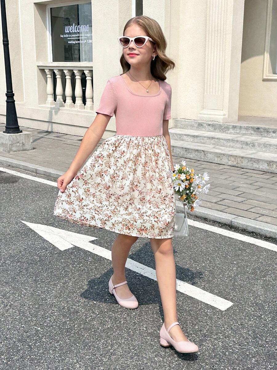Tween girl wearing an apricot short sleeve A-line dress featuring a round neck, high waist with a belt, and flared hem.