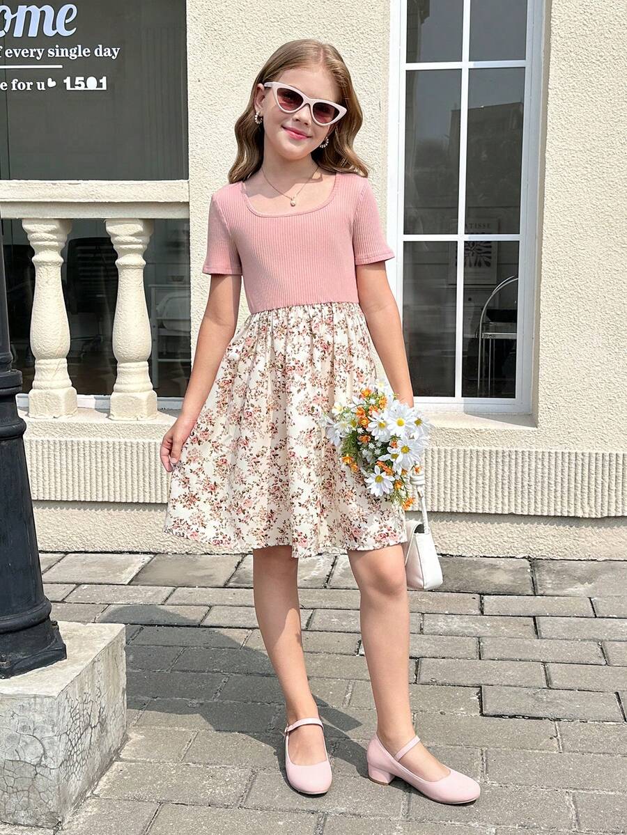 Tween girl wearing an apricot short sleeve A-line dress featuring a round neck, high waist with a belt, and flared hem.