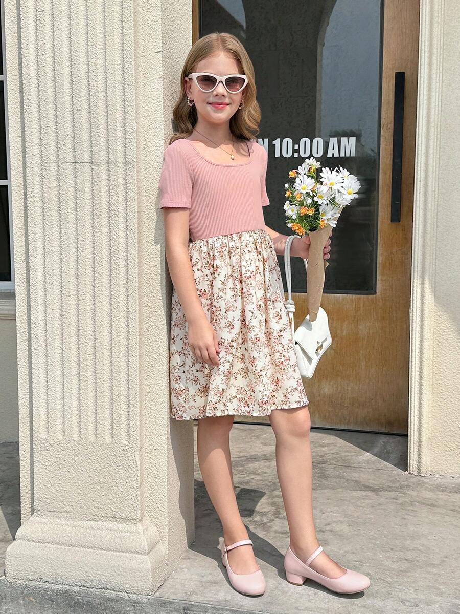 Tween girl wearing an apricot short sleeve A-line dress featuring a round neck, high waist with a belt, and flared hem.