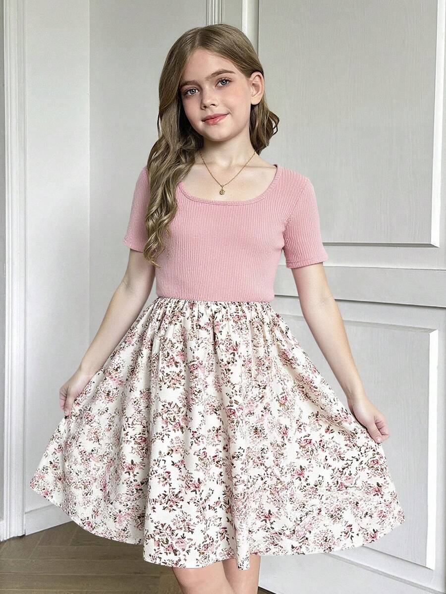 Tween girl wearing an apricot short sleeve A-line dress featuring a round neck, high waist with a belt, and flared hem.