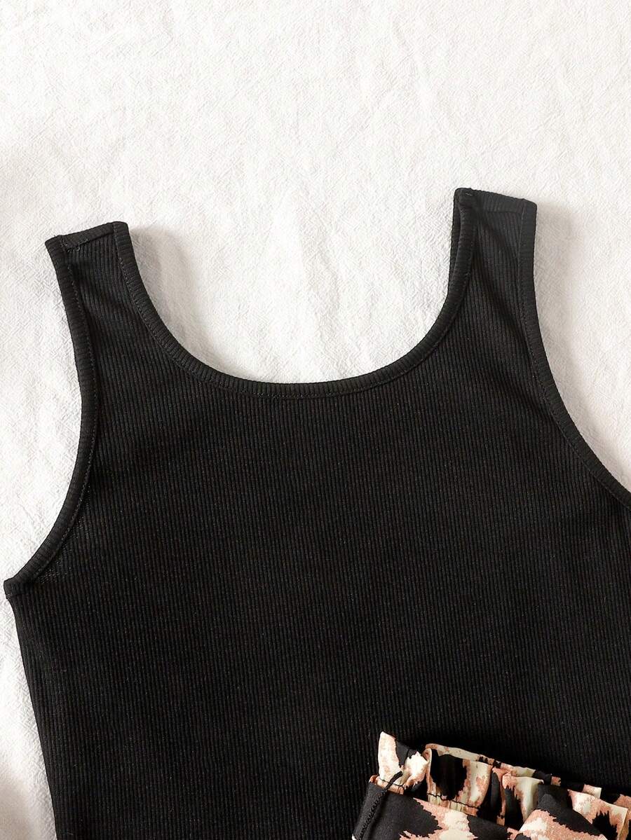 Tween girl wearing a casual 2-piece set featuring a black rib-knit scoop neck tank top and leopard print paperbag waist shorts with a matching belt.