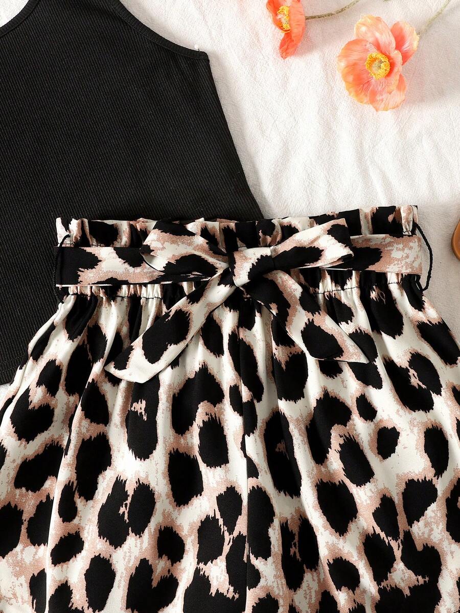 Tween girl wearing a casual 2-piece set featuring a black rib-knit scoop neck tank top and leopard print paperbag waist shorts with a matching belt.