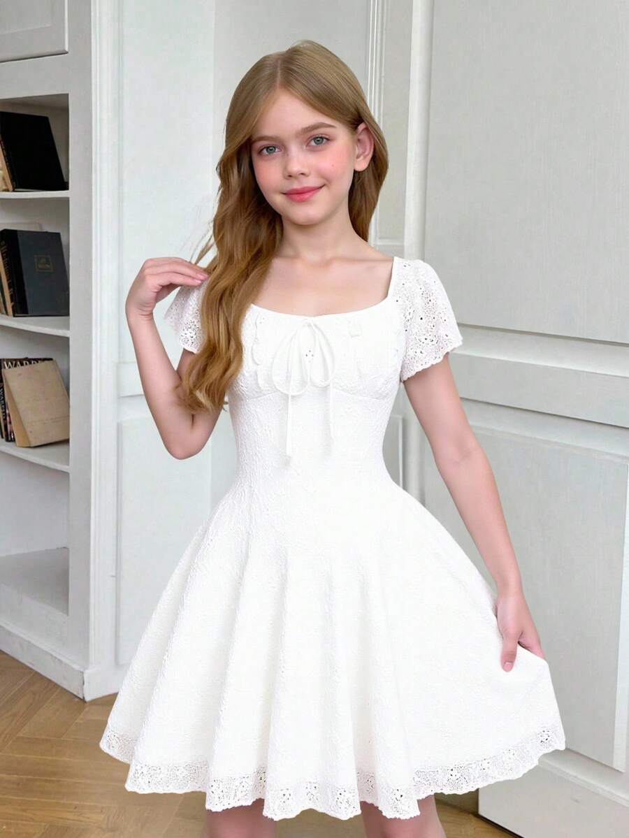 White eyelet lace A-line mini dress for tween girls with short puff sleeves, sweetheart neckline, high waist, and flared hem