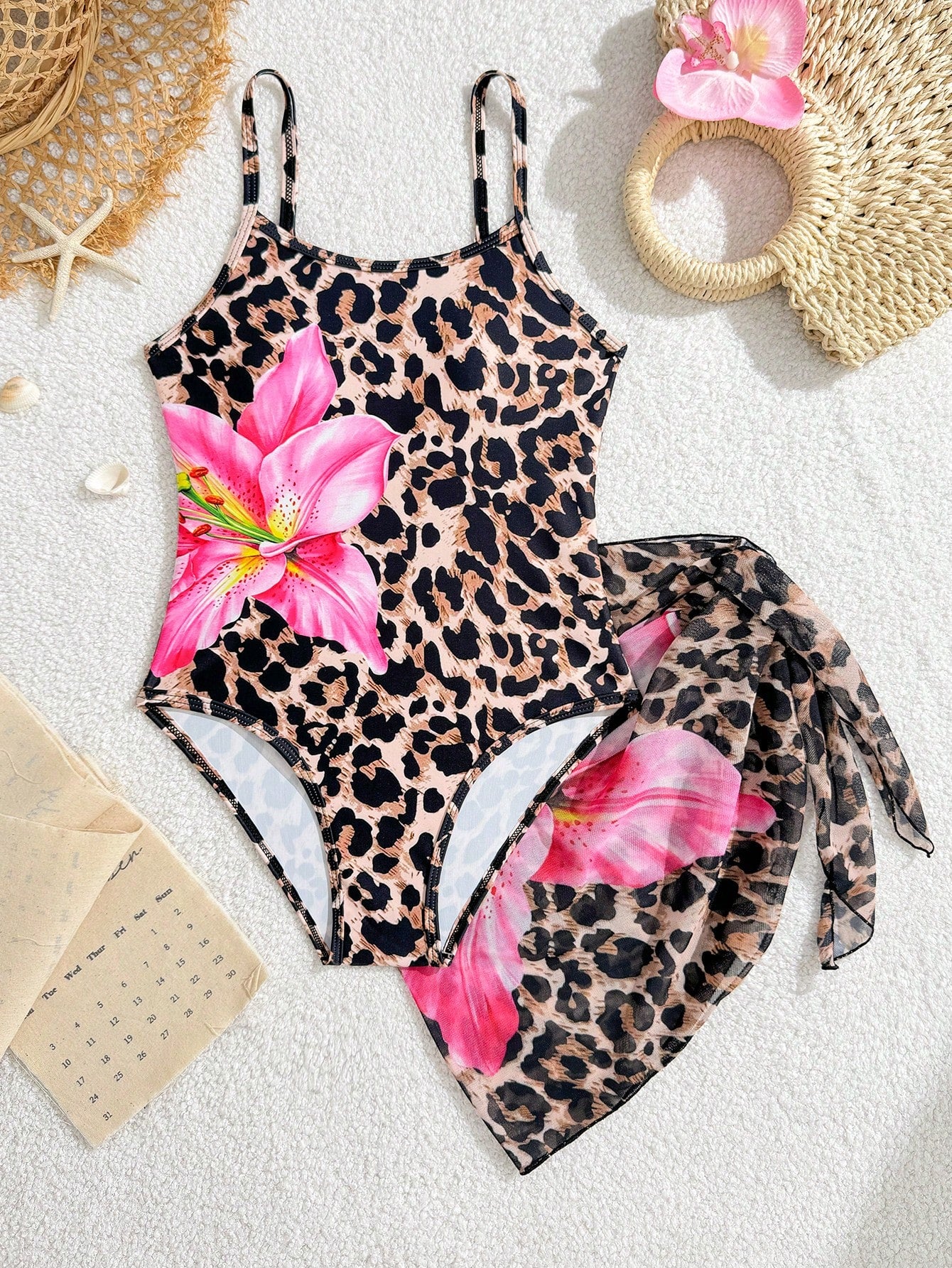 Multicolor girls' one-piece swimsuit with a bowknot pattern and spaghetti straps, shown with a black-trim triangle sarong in a 2-piece beachwear set.