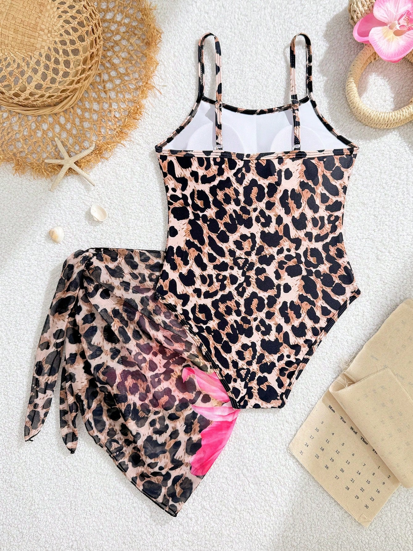 Multicolor girls' one-piece swimsuit with a bowknot pattern and spaghetti straps, shown with a black-trim triangle sarong in a 2-piece beachwear set.