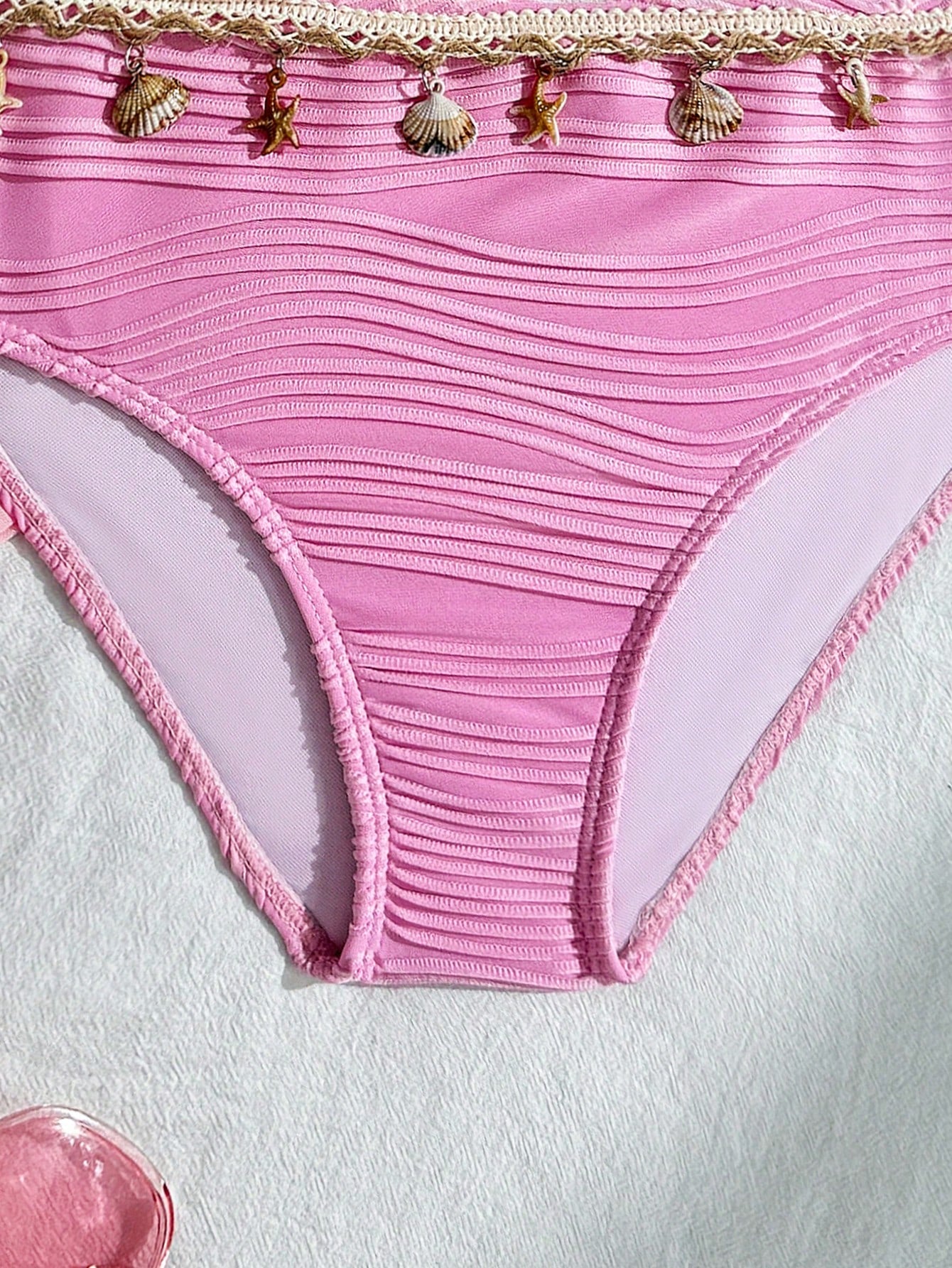 Tween girls bikini set with shell and starfish woven band details, spaghetti strap sleeveless top, and mid-waist skirt-style bottom in blue.