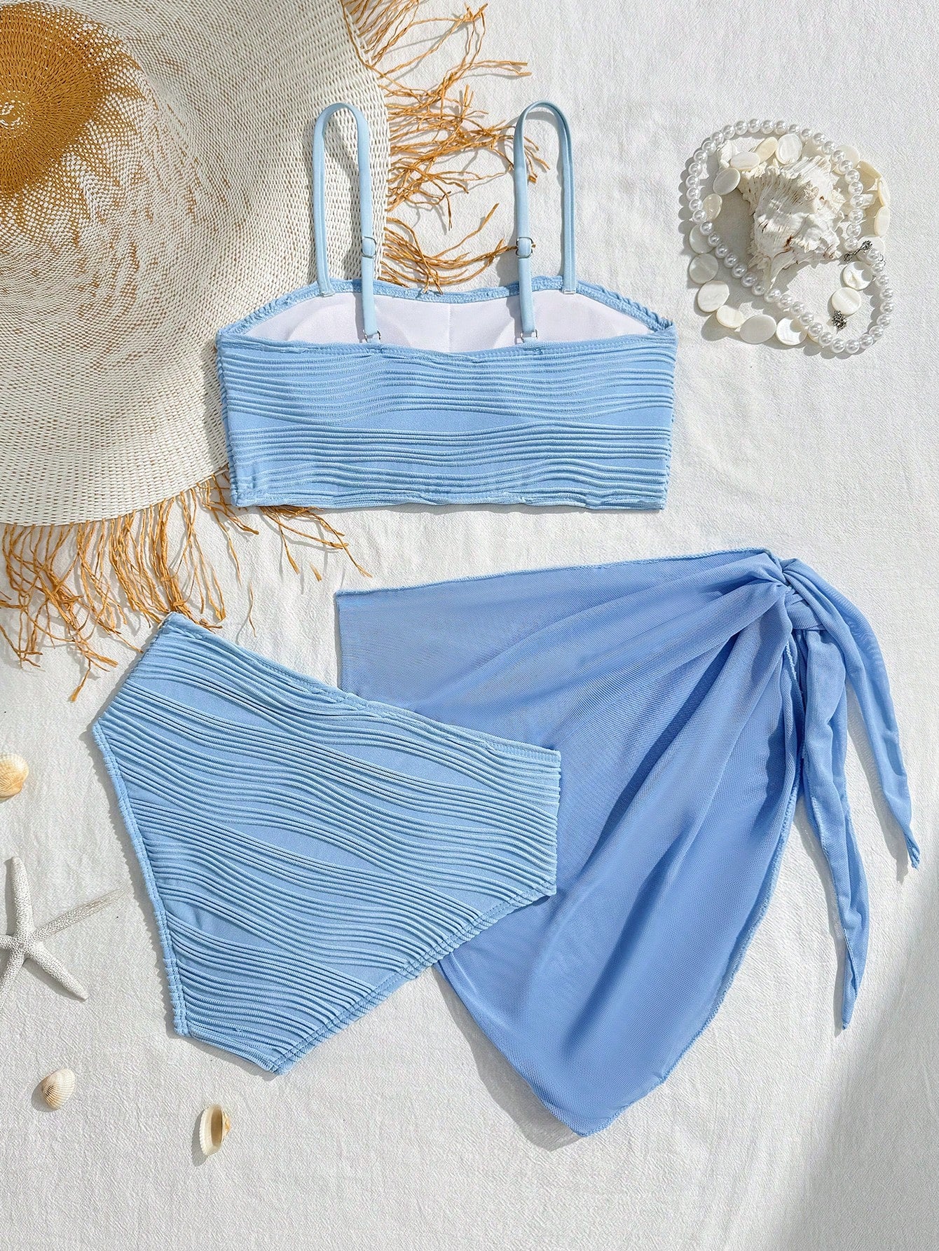 Tween girls bikini set with shell and starfish woven band details, spaghetti strap sleeveless top, and mid-waist skirt-style bottom in blue.