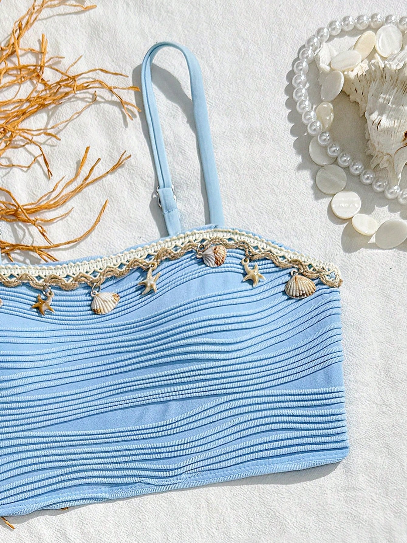 Tween girls bikini set with shell and starfish woven band details, spaghetti strap sleeveless top, and mid-waist skirt-style bottom in blue.