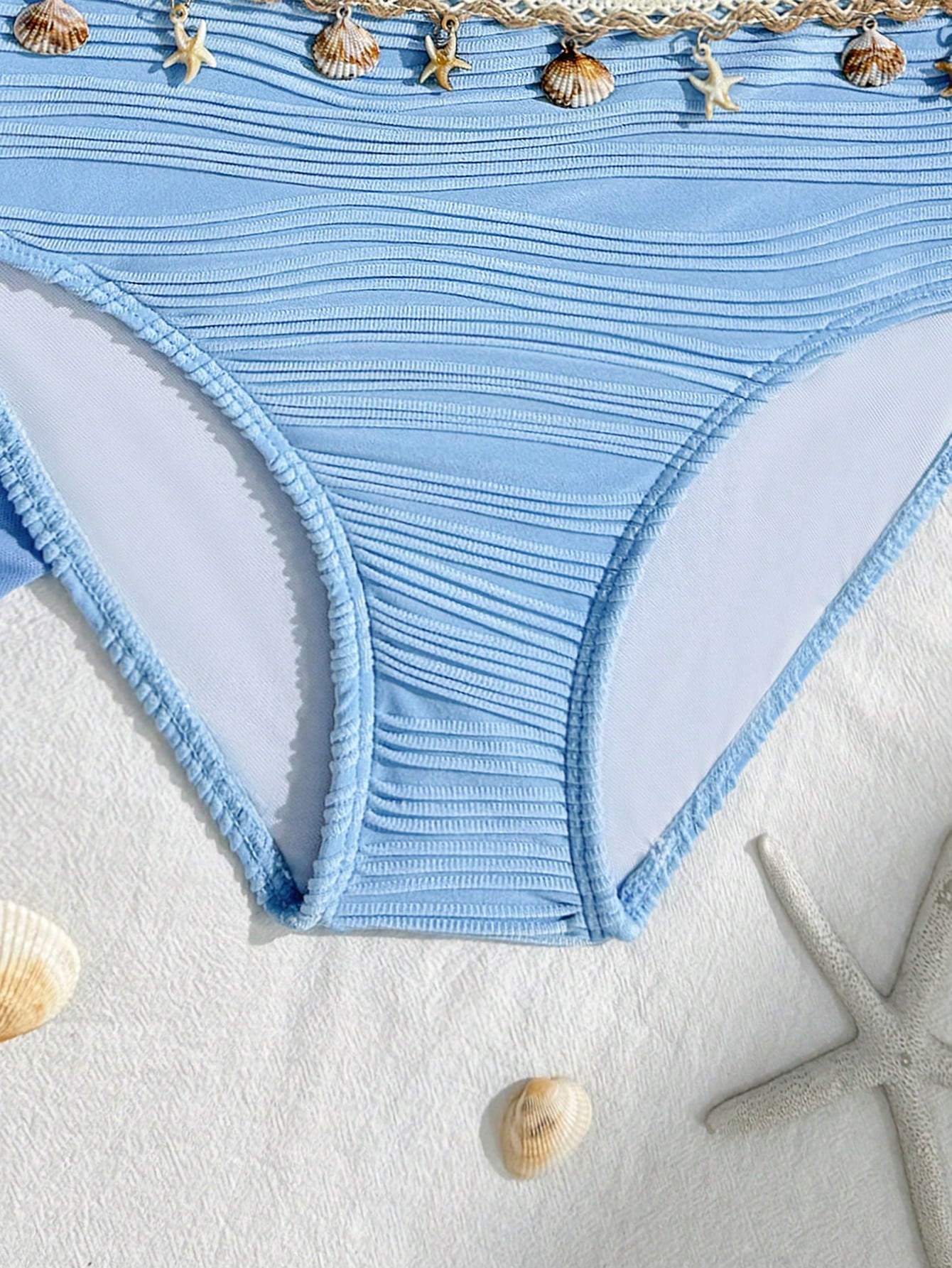 Tween girls bikini set with shell and starfish woven band details, spaghetti strap sleeveless top, and mid-waist skirt-style bottom in blue.