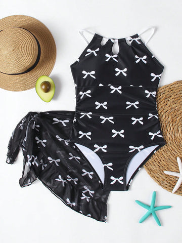 Girls black and white one-piece swimsuit set with cut-out detail, spaghetti straps, sleeveless fitted design, and matching skirt bottom for vacation swimwear.