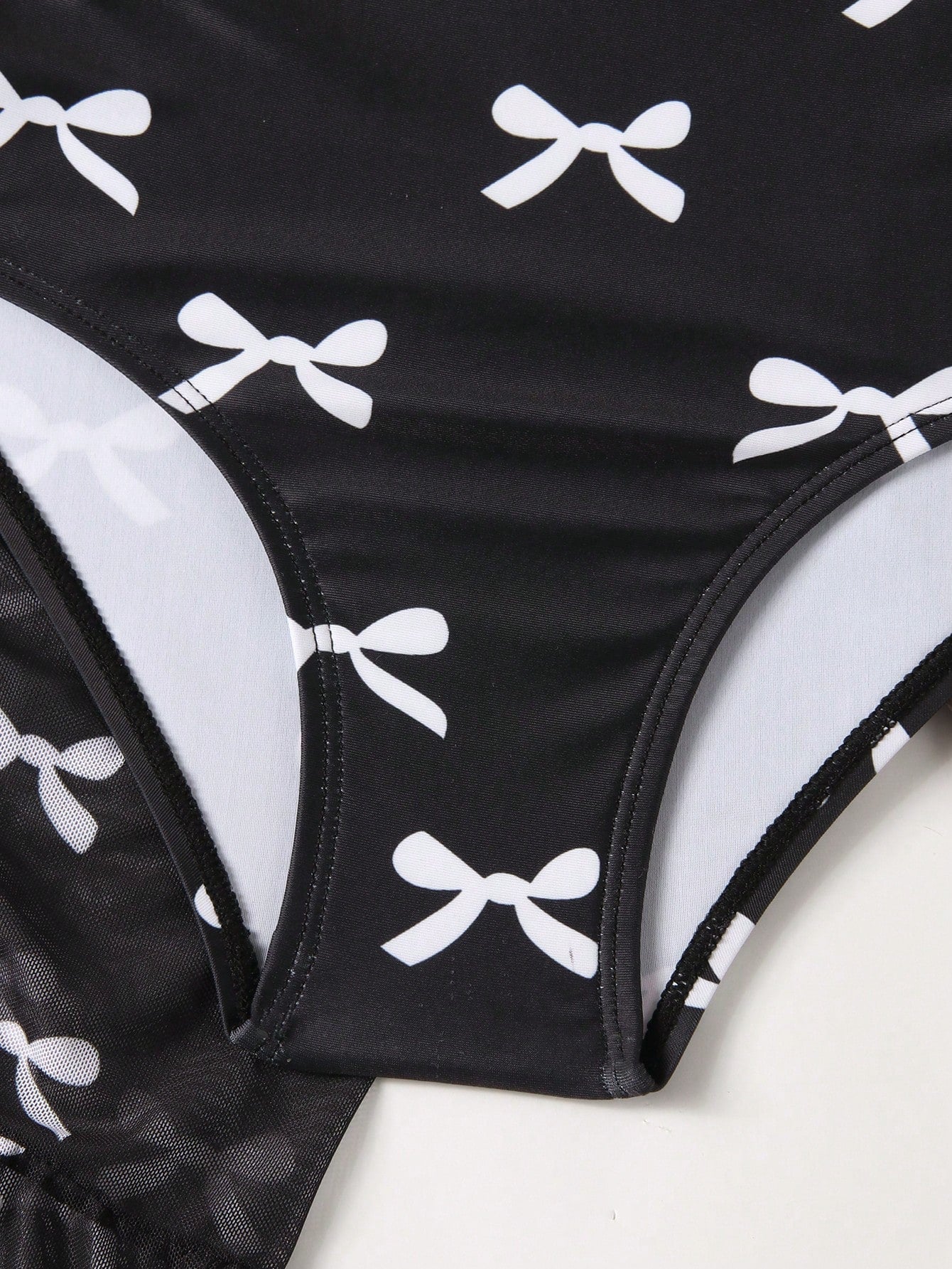 Girls black and white one-piece swimsuit set with cut-out detail, spaghetti straps, sleeveless fitted design, and matching skirt bottom for vacation swimwear.
