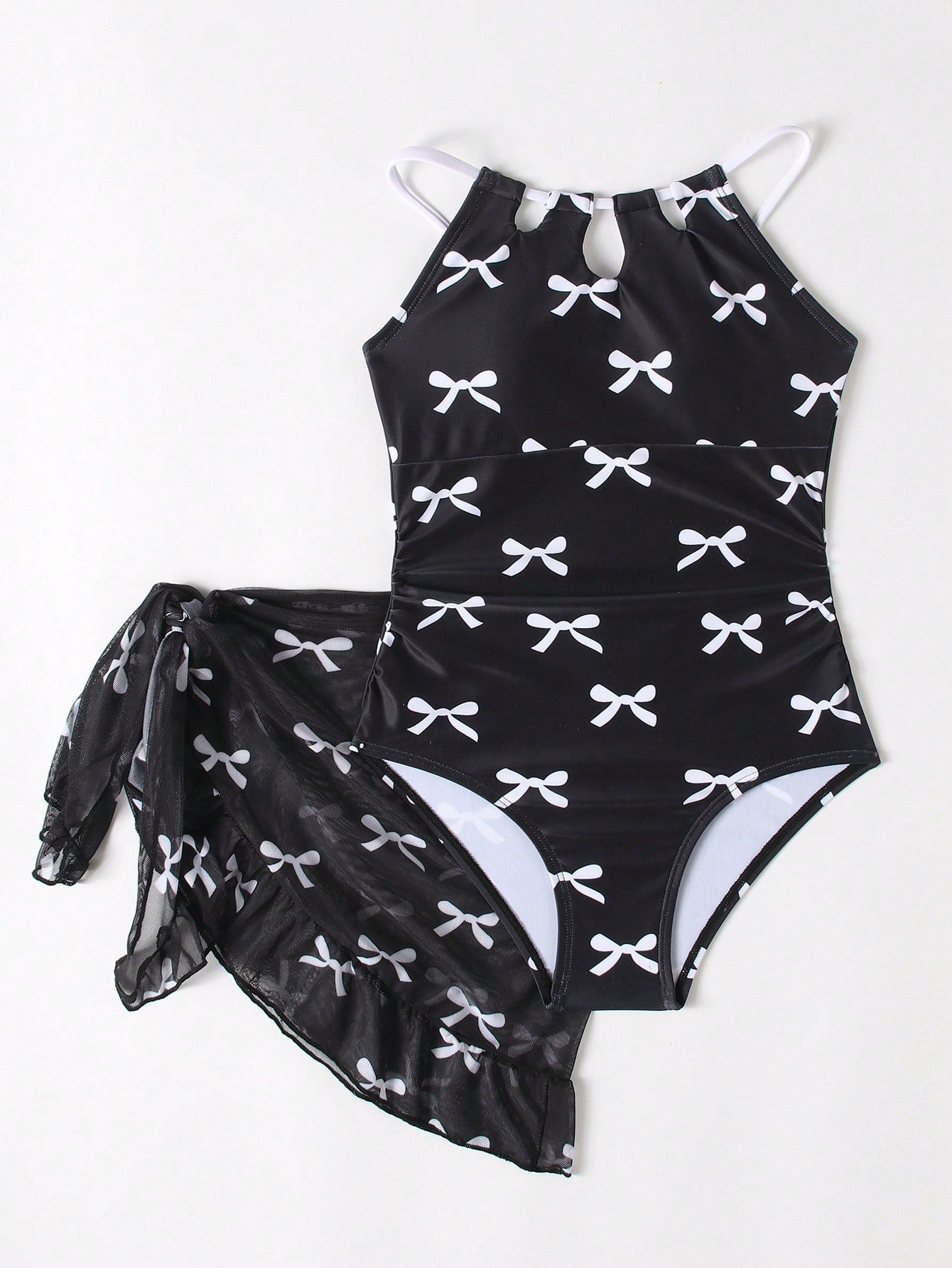 Girls black and white one-piece swimsuit set with cut-out detail, spaghetti straps, sleeveless fitted design, and matching skirt bottom for vacation swimwear.