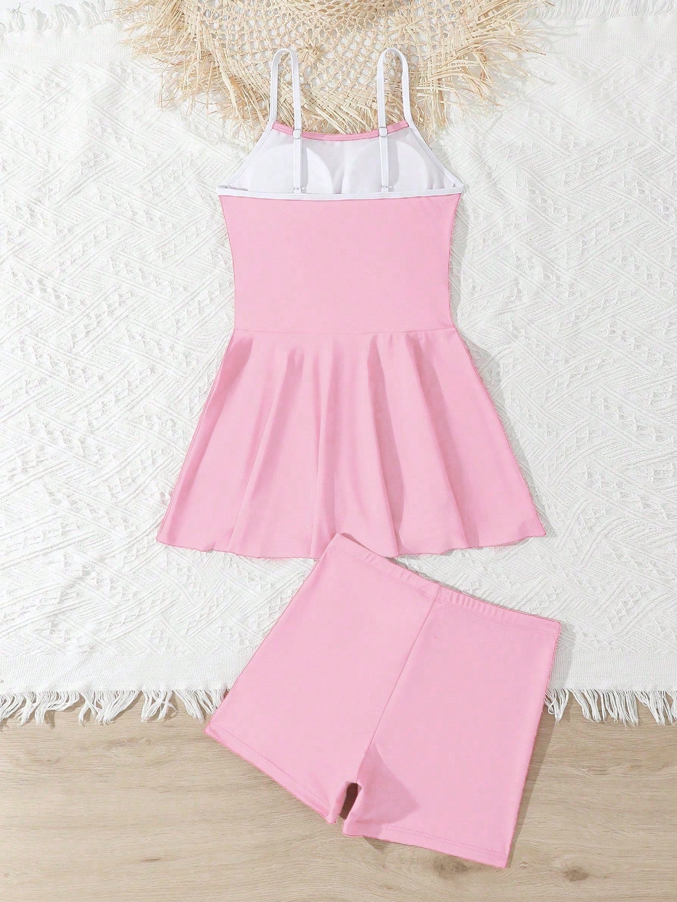Tween girls black two-piece tankini swimwear set featuring a spaghetti strap sleeveless top with cutout detail and contrast piping, paired with short swim shorts.