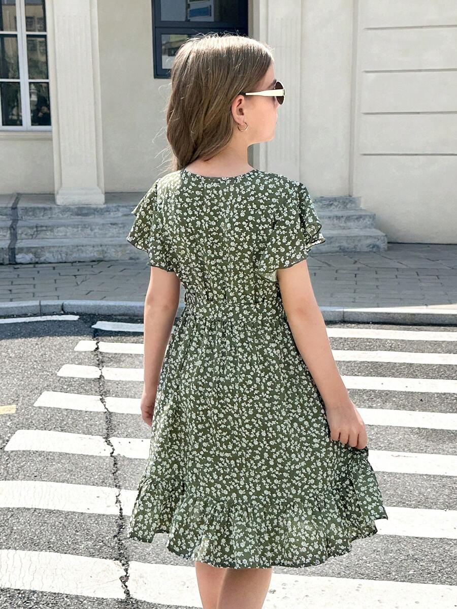 Tween girl wearing a black ditsy floral A-line short dress with V-neckline and flounce short sleeves.