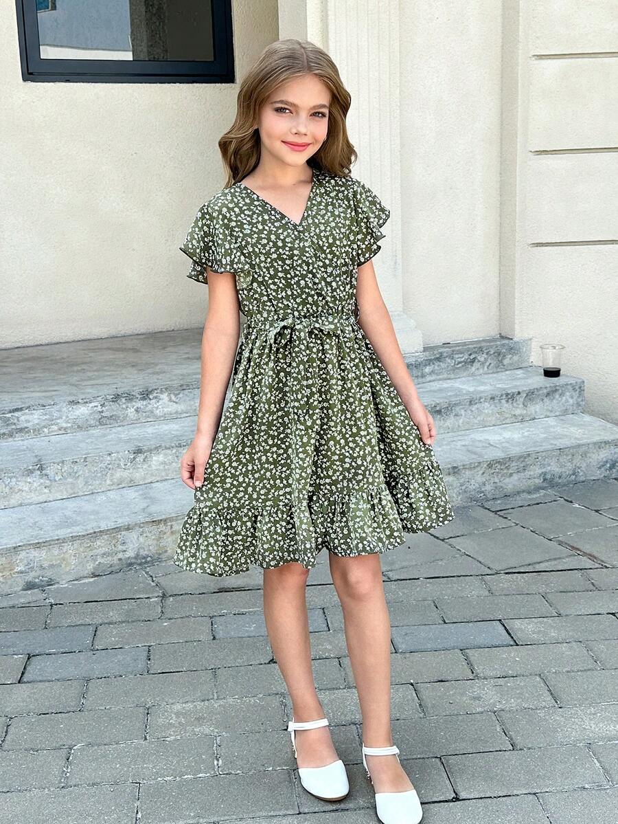 Tween girl wearing a black ditsy floral A-line short dress with V-neckline and flounce short sleeves.