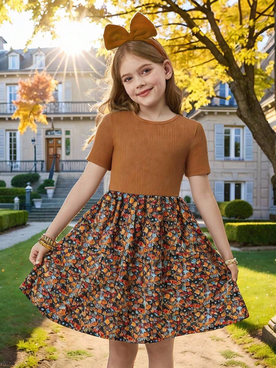 Tween girl wearing an apricot short sleeve A-line dress featuring a round neck, high waist with a belt, and flared hem.