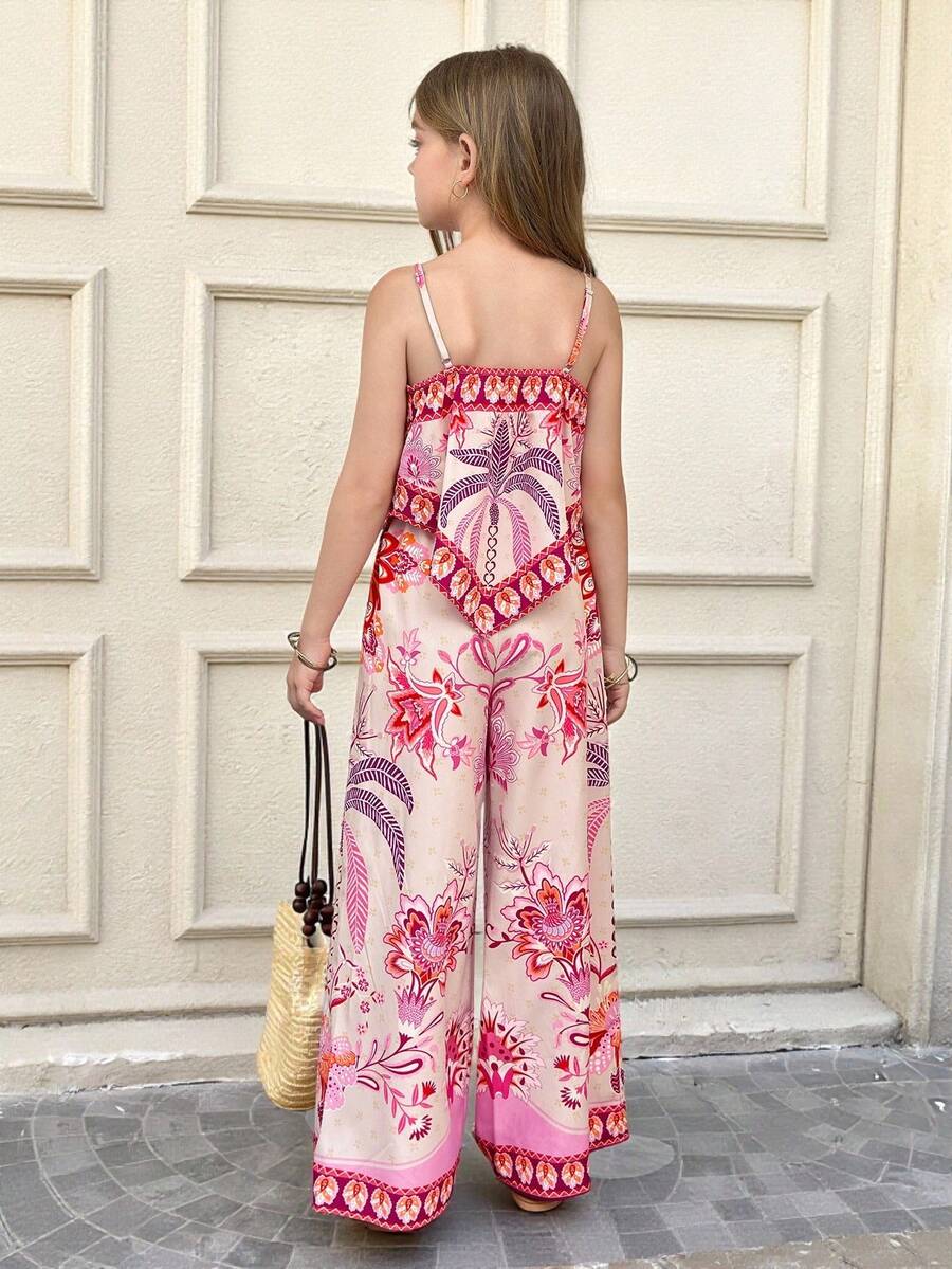 Tween girl wearing a pink boho floral printed 2-piece set with a spaghetti strap cami top and matching belted high-waist long pants.