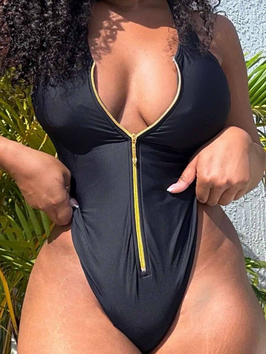 Dark green women's one-piece swimsuit featuring a zipper V-neckline and backless design.