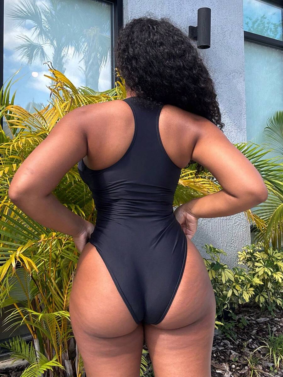 Dark green women's one-piece swimsuit featuring a zipper V-neckline and backless design.