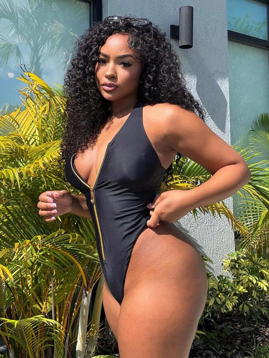 Dark green women's one-piece swimsuit featuring a zipper V-neckline and backless design.