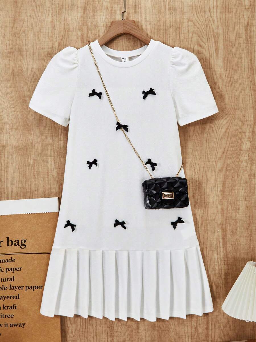 Tween girls apricot short-sleeve pleated smock dress with 3D bow decor and round neckline.