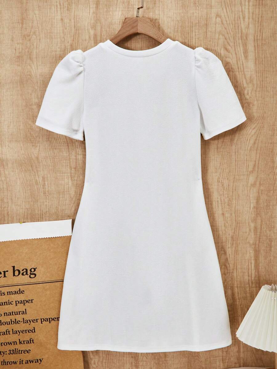 Tween girls apricot short-sleeve pleated smock dress with 3D bow decor and round neckline.