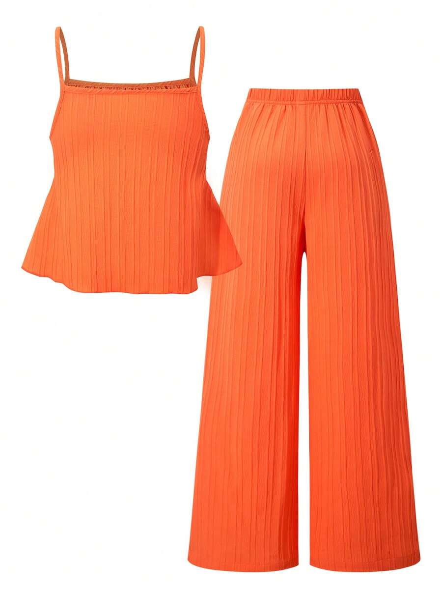 Tween girl wearing an apricot 2-piece outfit set featuring a shirred spaghetti strap short cami top and matching wide-leg long pants.